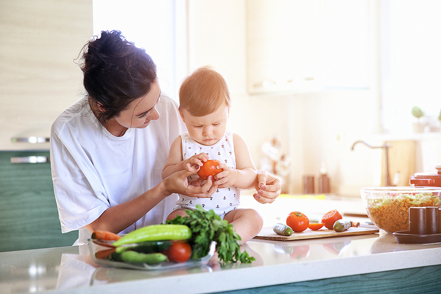 Un bebé y su madre observando las verduras