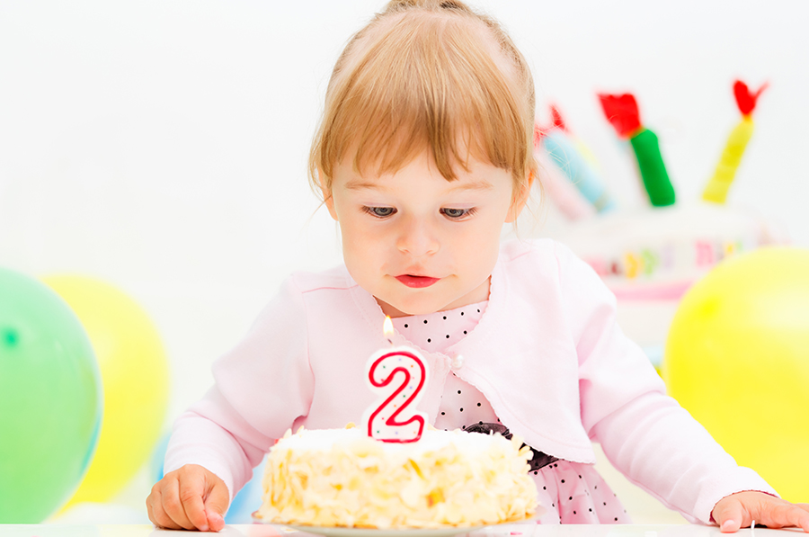 Una niña con su pastel de cumpleaños